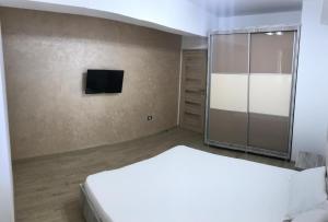 a bedroom with a bed and a flat screen tv at Ideal MoonLight Residence in Mamaia