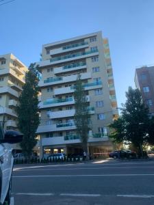 a large apartment building with cars parked in a parking lot at Ideal MoonLight Residence in Mamaia