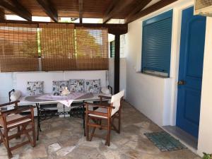 a patio with a table and chairs and a blue door at Casa di Giorgio in Nikiana