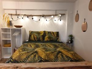 a bedroom with a bed with a green comforter and lights at Studio Belga Begijnhof Tongeren in Tongeren