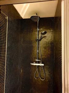 een douche met twee tennisrackets aan de muur bij Studio Het Begijntje Tongeren in Tongeren