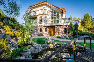 ein Haus mit einem Teich davor in der Unterkunft Nad Stawami in Karthaus