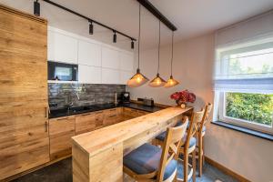 cocina con mesa de madera y sillas en Nad Stawami, en Kartuzy