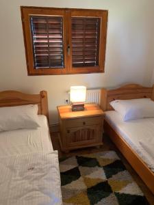 ein Schlafzimmer mit 2 Betten und einer Lampe auf einem Nachttisch in der Unterkunft NG Apartmani Tornik Zlatibor in Zlatibor