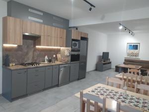 a kitchen with stainless steel appliances and a table and chairs at Noclegi przy Skawie in Zator
