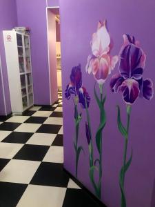 una pared púrpura con flores púrpuras pintadas en ella en WonderHostel Central, en San Petersburgo