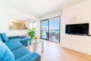 a living room with a blue couch and a tv at Sa Maniga 5E in Cala Millor