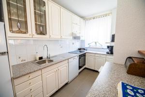 una cocina con armarios blancos y fregadero en Vila K29, en Bovec