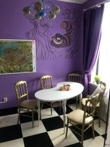 Habitación púrpura con mesa y sillas en WonderHostel Central, en San Petersburgo