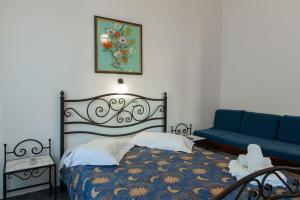a bedroom with a bed and a blue couch at Aristeides - Moscha Apartments in Platis Yialos Sifnos