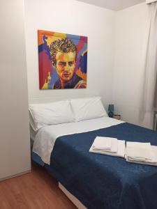 una camera da letto con un letto e un dipinto sul muro di Al teatro a Padova