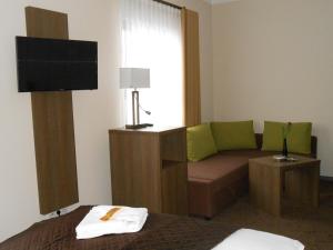a living room with a couch and a window at Hotel Weisse Elster in Zeitz