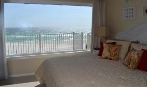 a bedroom with a bed and a large window at A View To Sea! West End! Sleeps 12! Hot Tub! in Panama City Beach