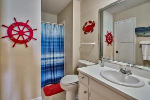 a bathroom with a sink and a toilet and a mirror at A View To Sea! West End! Sleeps 12! Hot Tub! in Panama City Beach +43 photos