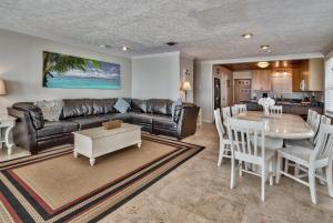 ein Wohnzimmer mit Sofa und Tisch in der Unterkunft Sand Blast - Lovely Beachfront Home With Tons Of Space! in Panama City Beach