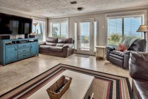 ein Wohnzimmer mit Ledersofas und einem TV in der Unterkunft Sand Blast - Lovely Beachfront Home With Tons Of Space! in Panama City Beach