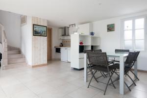 cocina y comedor con mesa y sillas en Maison Campanule en La Flotte