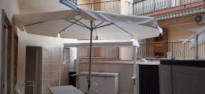 einen weißen Regenschirm auf dem Balkon in der Unterkunft Il Galeone in Marina di Ragusa