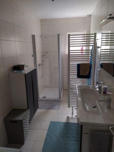 W łazience znajduje się prysznic, umywalka i wanna. w obiekcie Ferienhaus Middenmank w mieście Emden