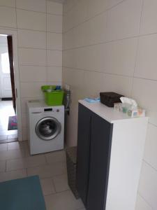 a laundry room with a washing machine and a counter at Ferienhaus Middenmank in Emden