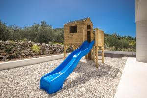 un parque infantil con un tobogán azul y una casa de aves en Villa Hileja en Marina