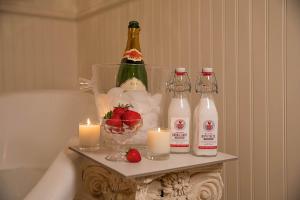 un tavolo con bottiglie di champagne, candele e fragole di Red Gate Inn a McKinney