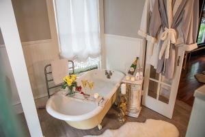ein Badezimmer mit einer Badewanne mit Blumen. in der Unterkunft Red Gate Inn in McKinney
