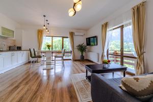 a living room with a couch and a table at Yael Luxury Apartments 2 in Buşteni