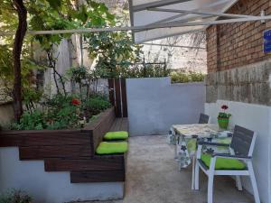 a patio with a table and chairs and plants at Apartments Belvedere in Rijeka