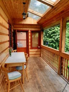 a wooden cabin with a table and chairs on a porch at Chata Konzajf in Hrabušice