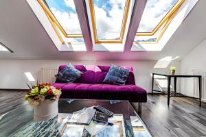 a living room with a purple couch and skylights at Yael Luxury Apartments 2 in Buşteni