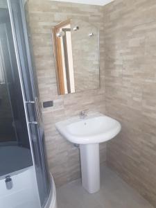 ein Badezimmer mit einem weißen Waschbecken und einer Dusche in der Unterkunft La Grolla in Aosta