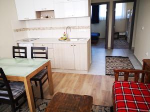 a kitchen with white cabinets and a table and chairs at Apartments&Camping ZIP in Kremna