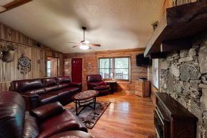 a living room with leather furniture and a stone wall at Horseshoe Bend in Whittier