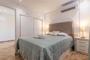 ein Schlafzimmer mit einem Bett mit einer blauen Decke in der Unterkunft Costa Paradise - BEACHFRONT APARTMENT in Fuengirola
