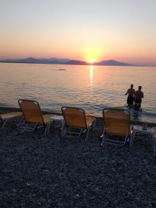 two men standing on the beach watching the sunset at Panorama in Pefki