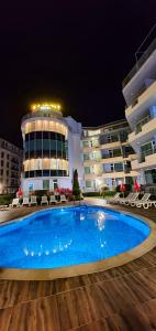 a swimming pool in front of a building at night at Favorit Aparthotel in Sunny Beach