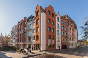 a group of people walking in front of a building at Happy Stay Tartaczna Residence I in Gdańsk