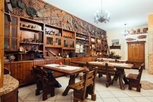 a kitchen with wooden tables and chairs in a room at TANIT Hotel Ristorante Storia del SulcisIglesiente in Carbonia