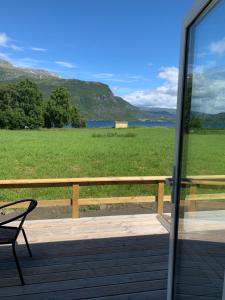 a porch with a chair and a view of a field at Mjøsvang Kafe in Vang I Valdres