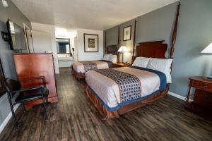 Giường trong phòng chung tại American Inn & Suites Russellville