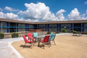 una mesa y sillas frente a un edificio en American Inn & Suites Russellville en Russellville