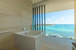 a bath tub sitting next to a large window at Barceló Maya Riviera - All Inclusive Adults Only - New Hotel in Xpu Ha