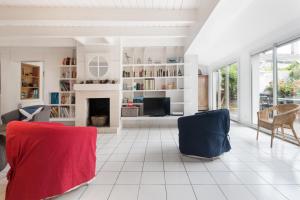Una sala de estar con dos sillas y una chimenea. en Maison Fleur-de-Sel, en Le Bois-Plage-en-Ré