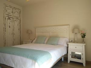 a bedroom with a white bed with two pillows at Apartamento El Manin in Villaviciosa