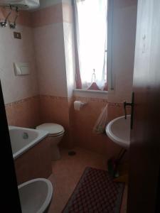 a bathroom with a toilet and a tub and a sink at Appartamento Risoli GP in Scalea