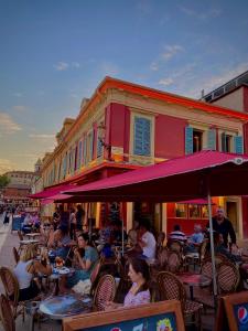 a group of people sitting at an outdoor restaurant at CHARMANT HOME - Mariesol in Nice