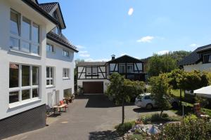 arial view of a house with a car parked in the driveway at Pension und Ferienwohnungen Schweinsberg in Medebach