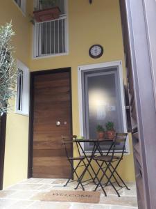 una mesa junto a una puerta con un reloj en la pared en Nuovissimo appartamento lungomare (check out 13:00), en Bari