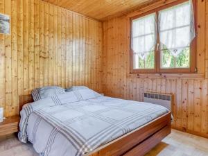 サン・モーリス・シュル・モセルにあるChalet in Saint Maurice sur Moselle with saunaの窓付きの木造の部屋のベッド1台